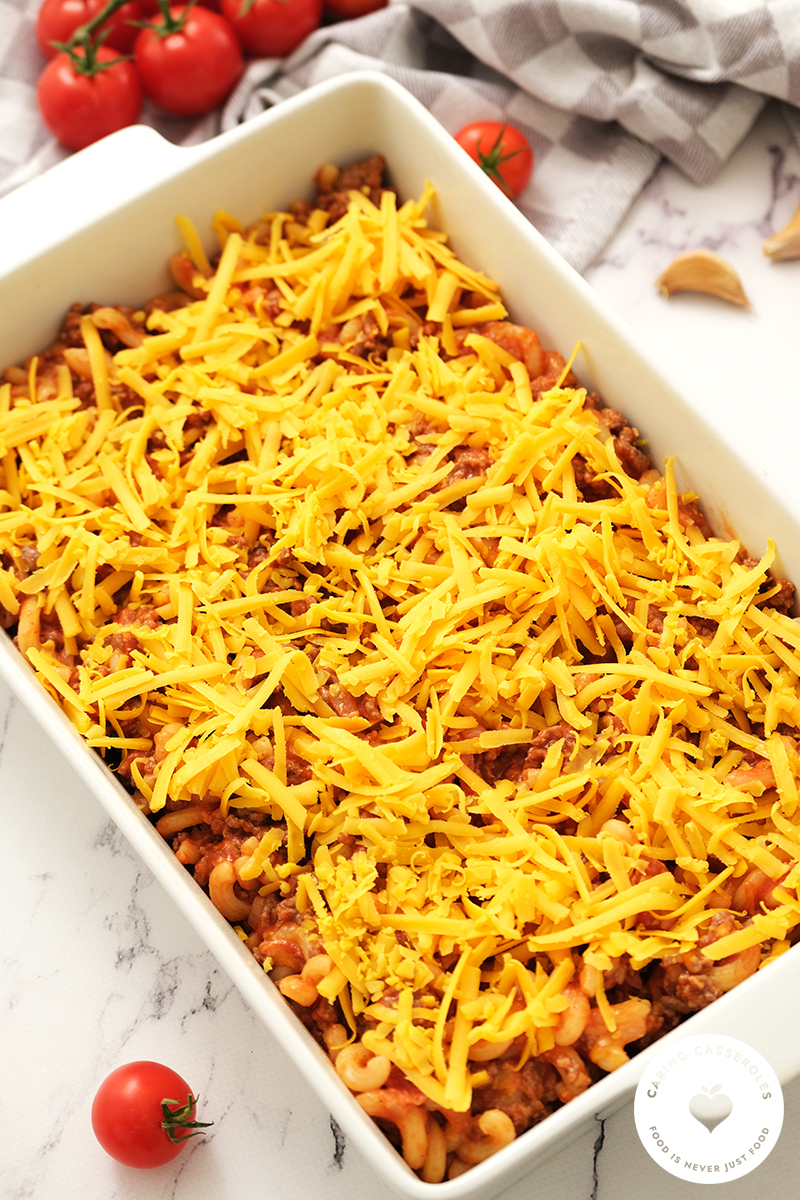 cheeseburger casserole topped with grated cheddar cheese
