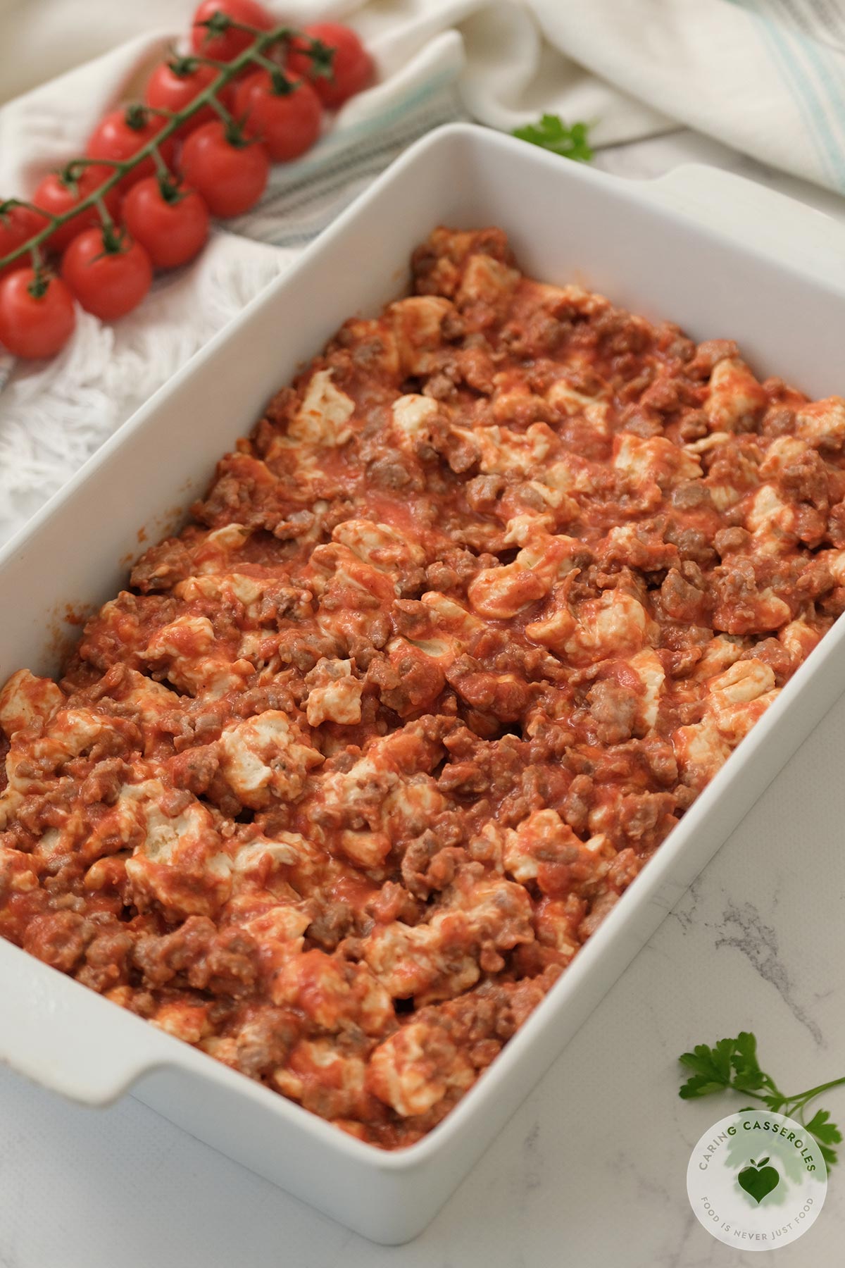 bubble pizza mixture spread into white casserole dish before baking