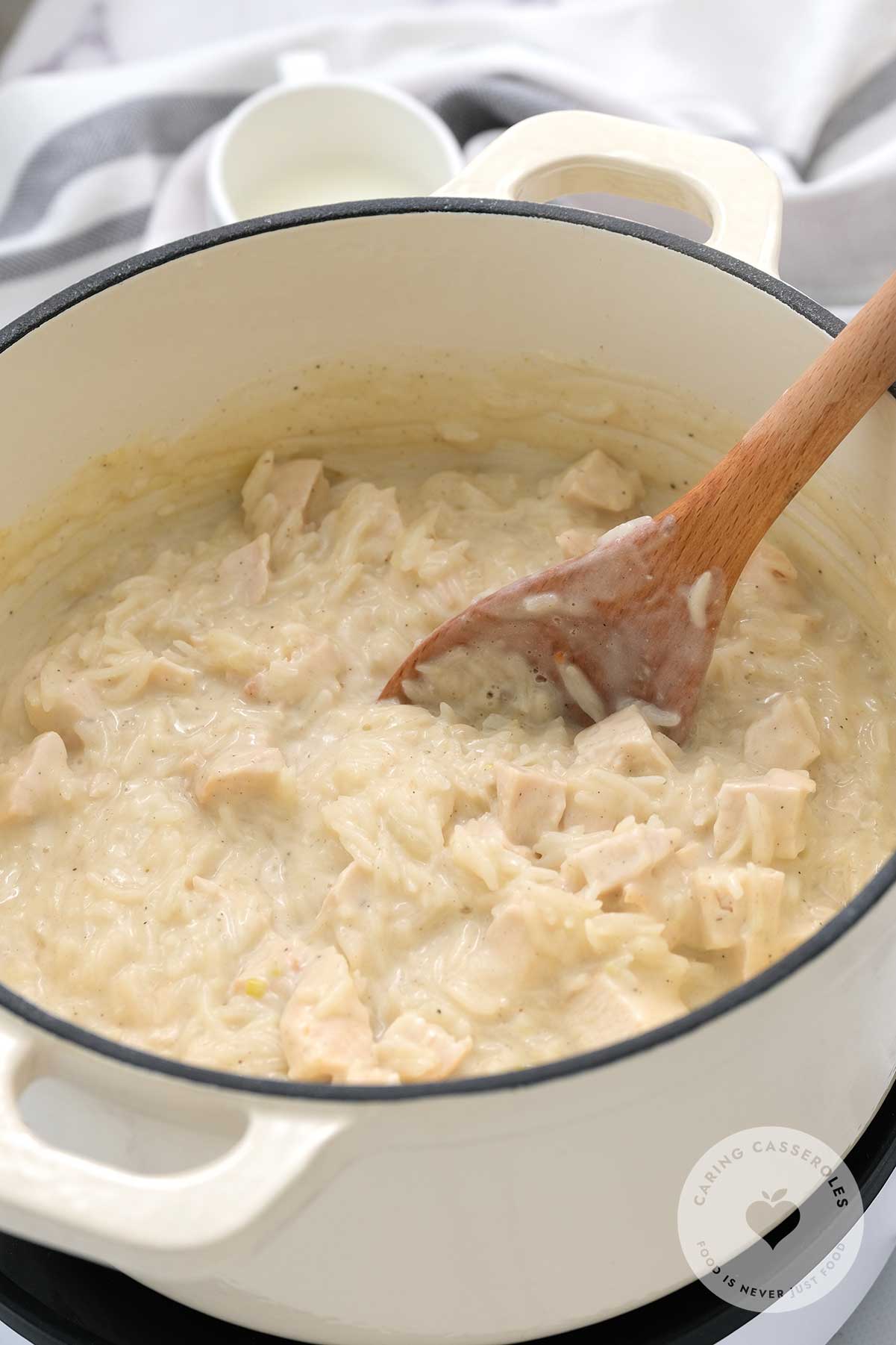 Rice being added to the chicken stock and milk mixture.
