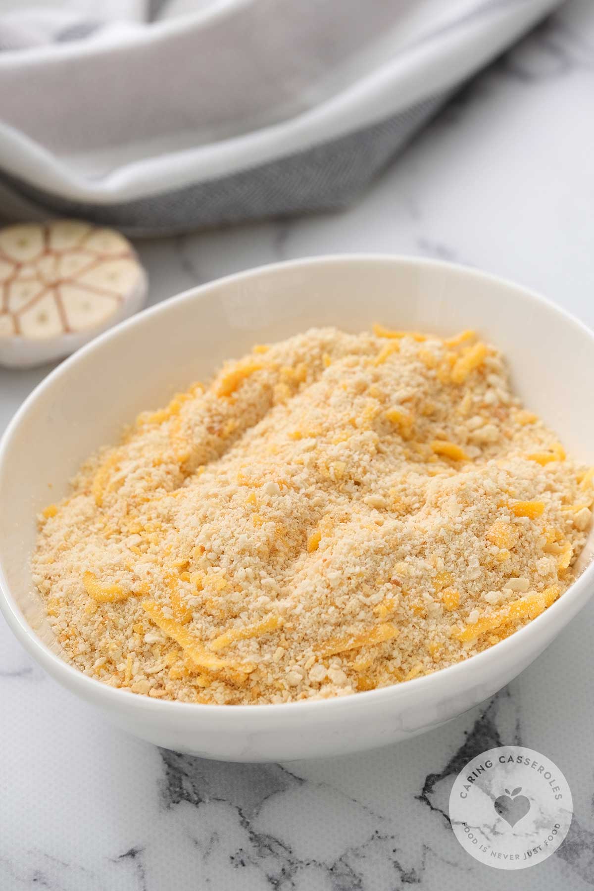 Chicken and rice mixture transferred to a casserole dish and covered with a mixture of crushed Ritz-style crackers, shredded cheddar and parmesan cheese.