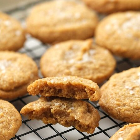 Dairy Free Gluten Free Peanut Butter cookies sitting on a baking rack with one broken in half.