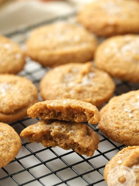 Dairy Free Gluten Free Peanut Butter cookies sitting on a baking rack with one broken in half.