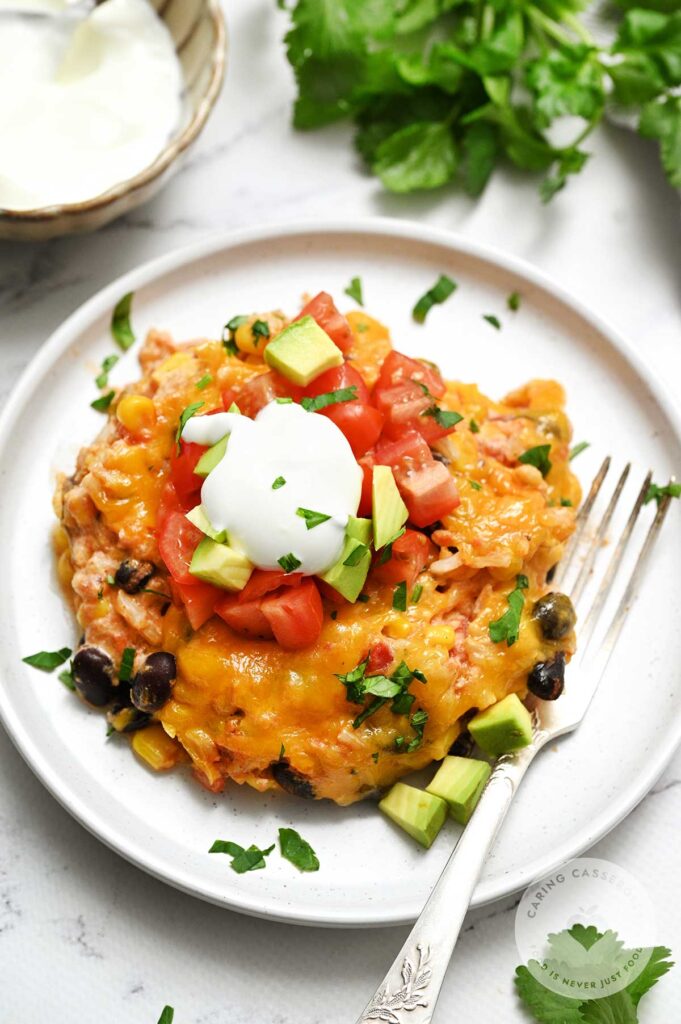 A portion of a southwest vegetarian bake served on a white plate made with a recipe from Caring Casserole.