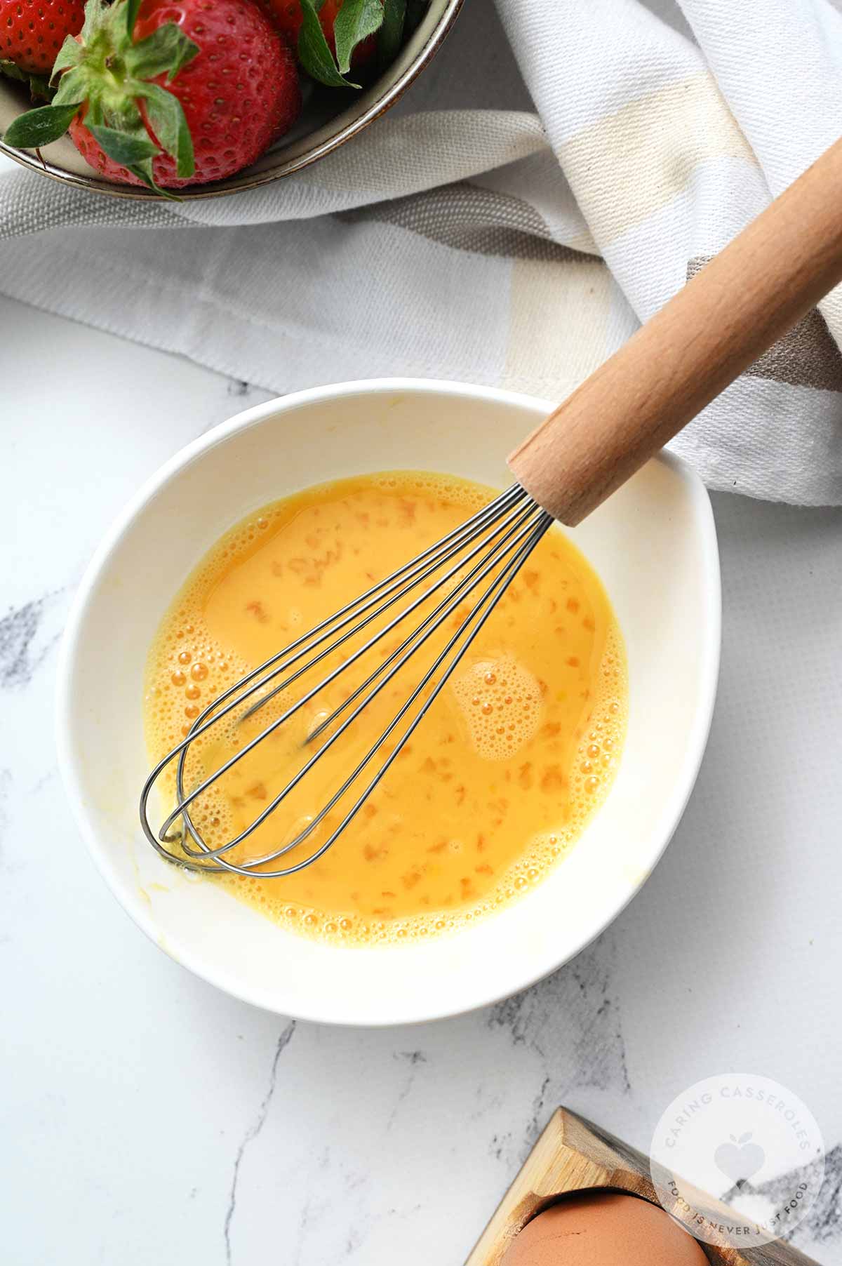 Egg and vanilla extract whisked together in a bowl.
