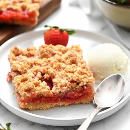 strawberry crumb bar on white plate with fork
