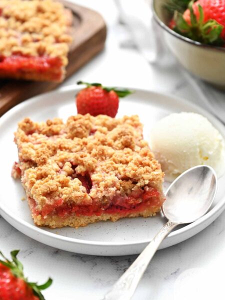 strawberry crumb bar on white plate with fork