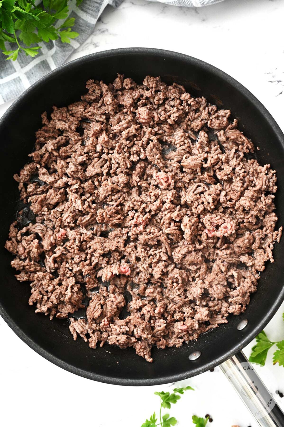 Ground beef browning in a skillet.