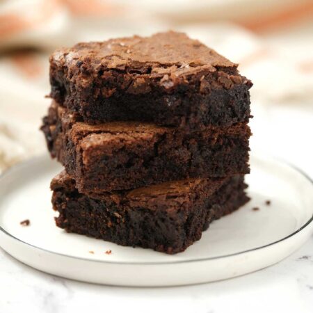 Three stacks of Chocolate Brownies on a white plate.