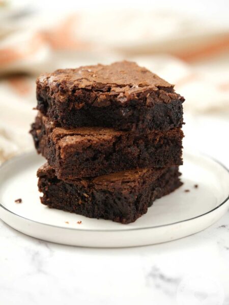 Three stacks of Chocolate Brownies on a white plate.