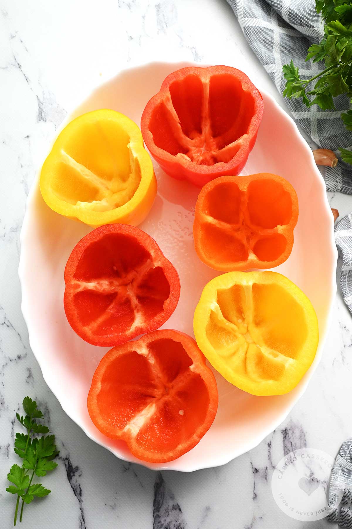 Red and yellow peppers in a baking dish after being prepped. 