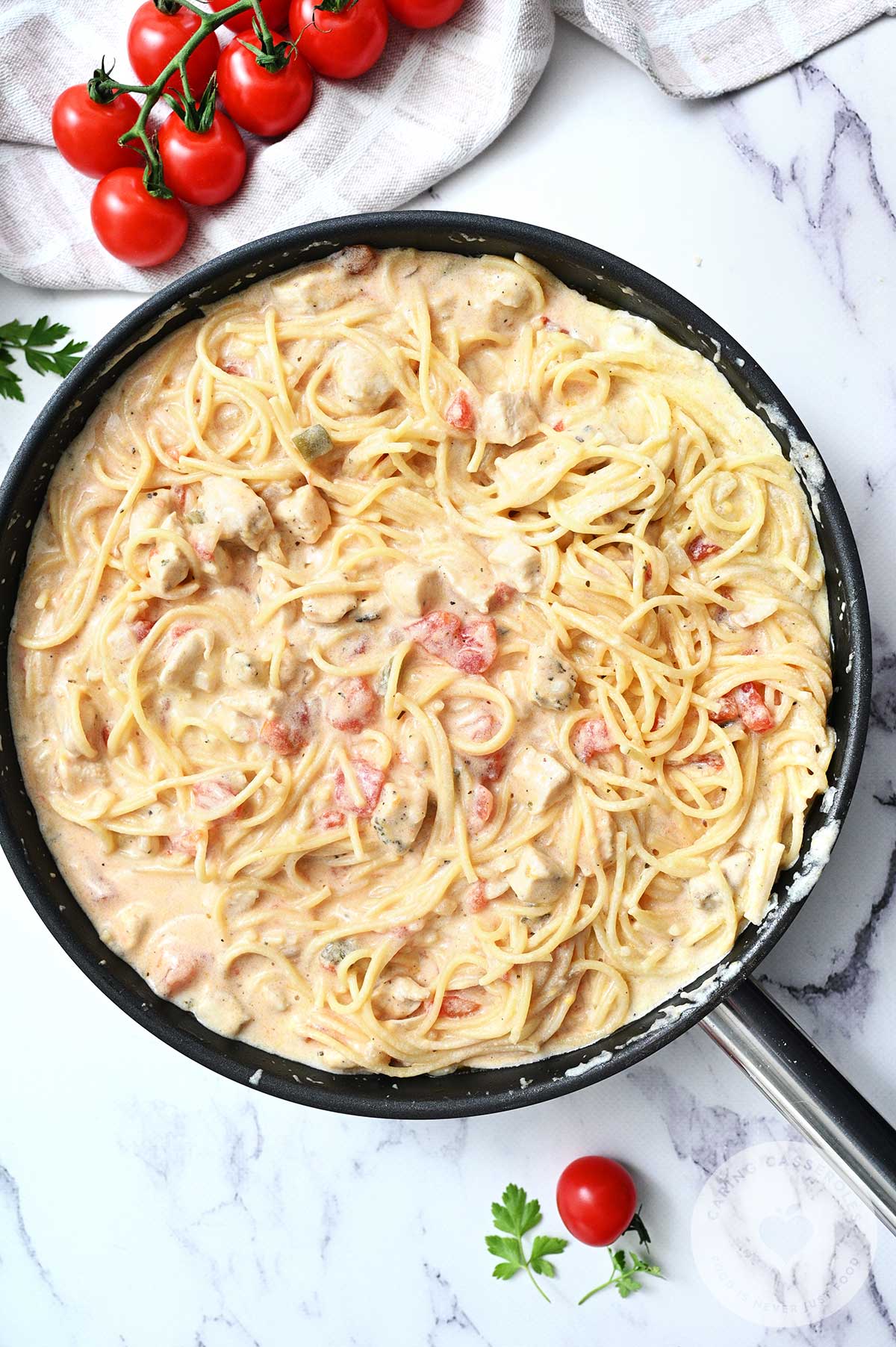 Diced chiles and tomatoes as well as spagetti added to the chicken mixture. 